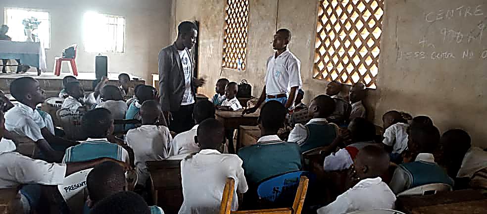 Two facilitators addressing students in a classroom during a community outreach program