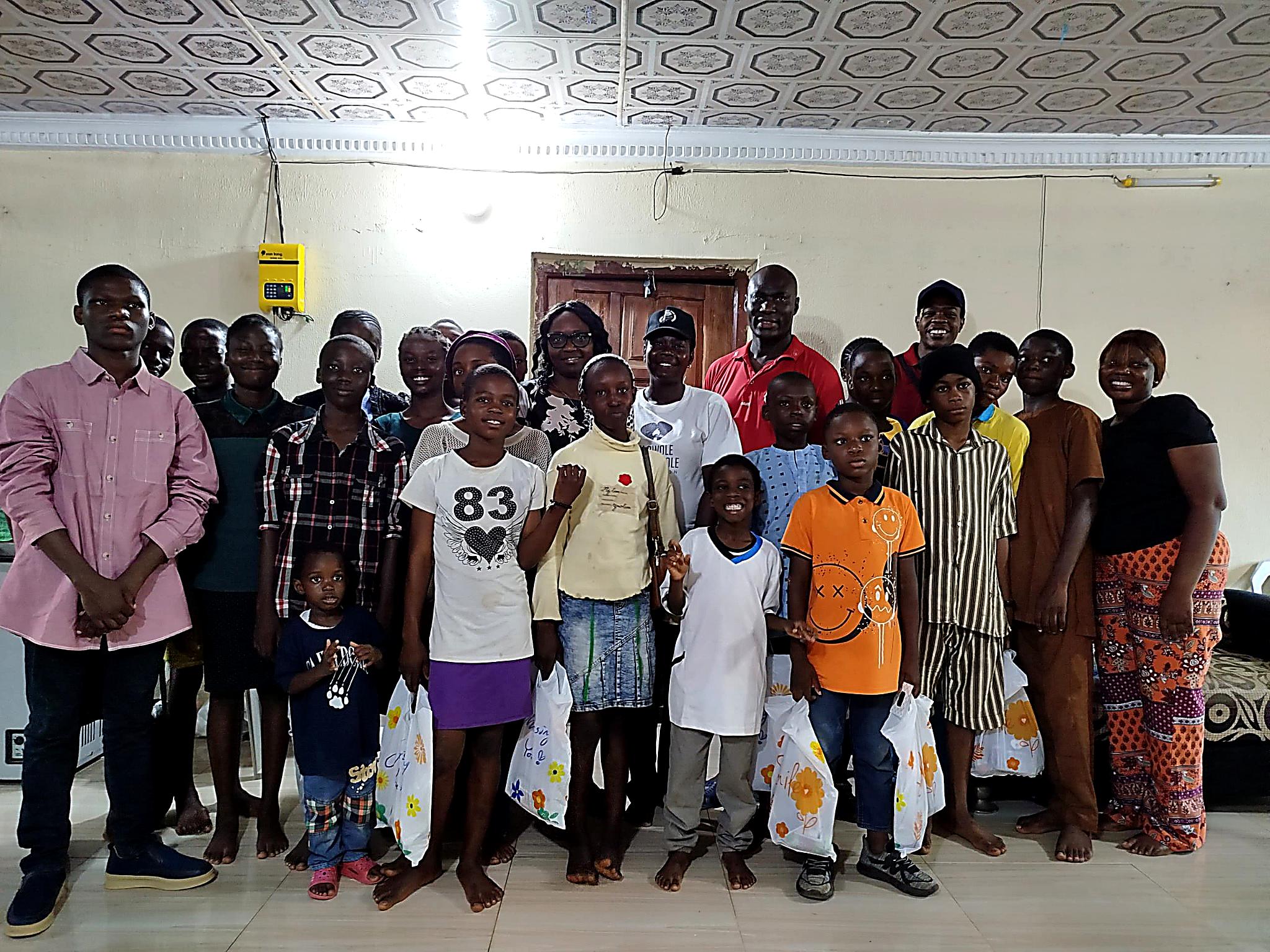 Group photo of TOAK Foundation community members including children and adults holding gift bags
